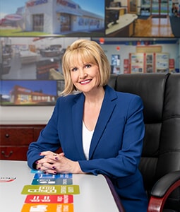 Catherine Monson poses with FASTSIGNS collateral 